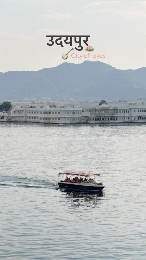 Tourist boat cruising on Lake Pichola with Taj Lake Palace and Aravalli hills in the background